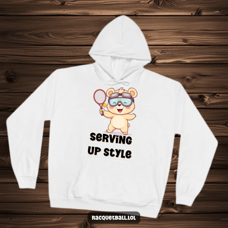 Funny hoodie depicting a giggling bear in oversized goggles enthusiastically serving a racquetball, exuding playful energy and sports-themed humor.