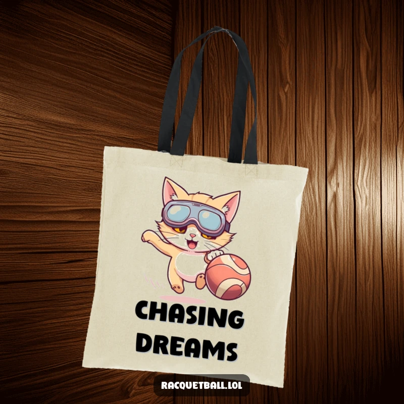 Funny tote bag with a cat wearing oversized goggles, enthusiastically chasing a fast-moving ball, perfect for carrying essentials humorously.