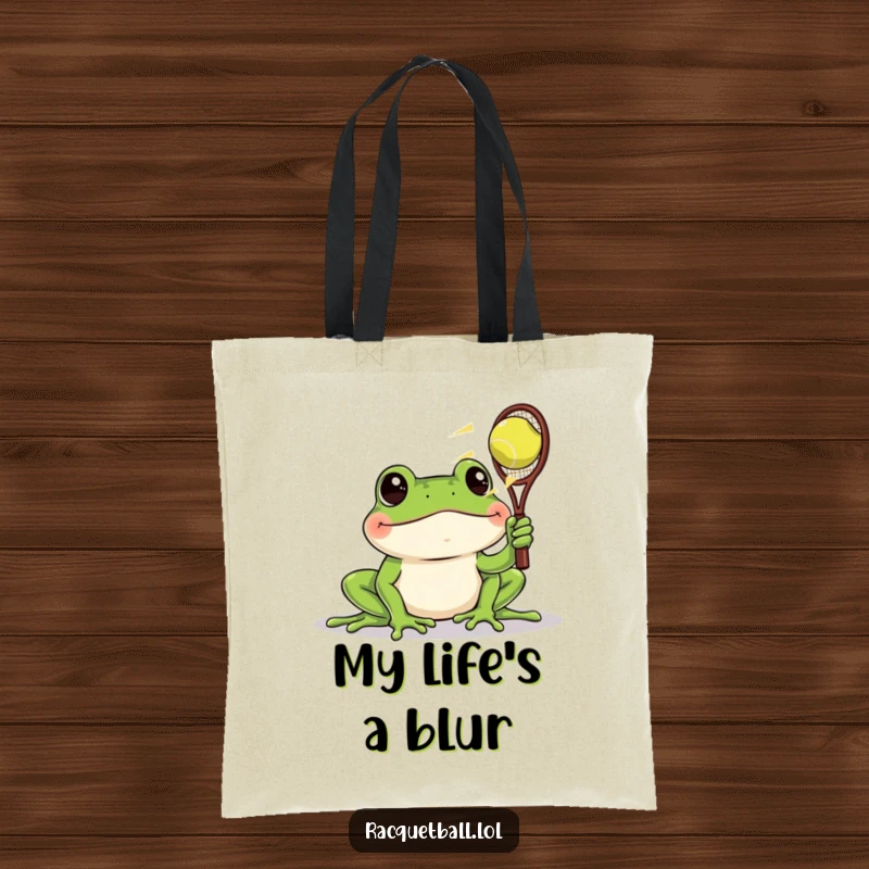 Funny tote bag depicting a frog with wide eyes watching a racquetball zoom past, a humorous accessory for keen observers.